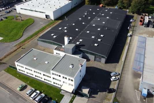 Luftaufnahme des Unternehmensstandorts von Baermann Magnettechnik mit Bürogebäude, Produktionshallen und Parkflächen