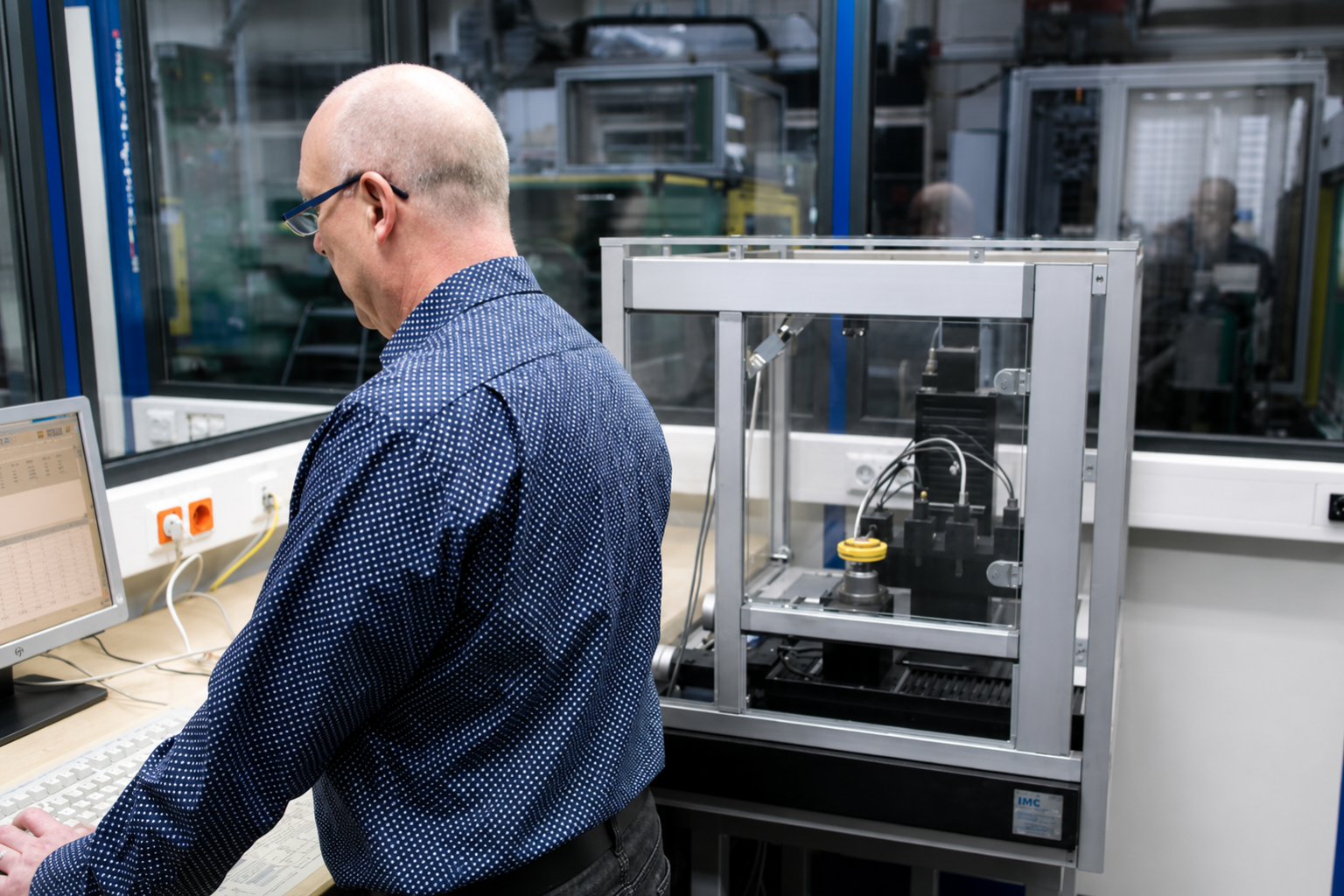 Mitarbeiter bei der computergestützten Prüfung technischer Bauteile an einer Messanlage im Qualitätslabor